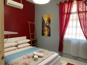 a bedroom with a bed with red walls and a window at Pasir Gudang Marissa Homestay in Masai