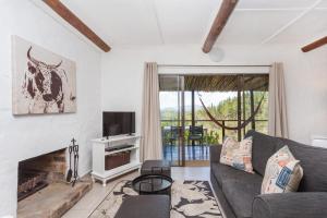 a living room with a couch and a fireplace at Forest Valley Cottages in Knysna