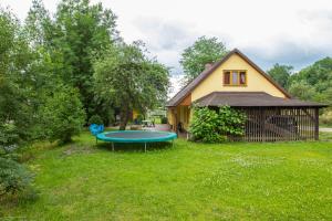 una pequeña casa con un trampolín verde en el patio en Family House Dolni Lanov en Dolní Lánov