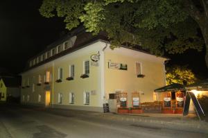 a white building on the side of a street at night at Gasthaus-Pension Schwarzer Graf in Windischgarsten