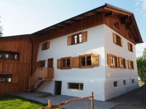 a large white building with wooden windows and a staircase at Ferienwohnung Lexar Hüs Oberstdorf in Oberstdorf
