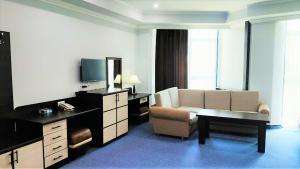 - un salon avec un canapé et une télévision dans l'établissement DDD Hotel, à Erevan