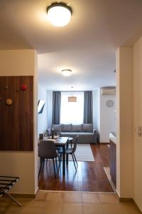 una sala de estar con una mesa y un sofá en Apartman Paradiso 211, en Vrnjačka Banja