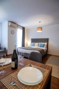 een kamer met een tafel met een fles wijn en een bed bij Apartman Paradiso 211 in Vrnjačka Banja