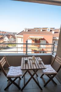 Una mesa de madera y dos sillas en un balcón. en Apartman Paradiso 211, en Vrnjačka Banja 9 fotos más