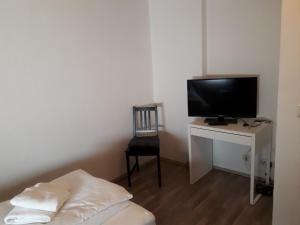 Habitación con TV y escritorio con silla. en Monteurhaus Scheidter 42, en Saarbrücken