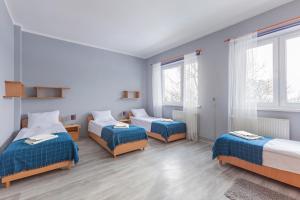 a hotel room with two beds and two windows at Meduza ośrodek wczasowy in Mrzeżyno