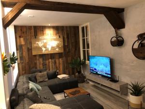 a living room with a couch and a flat screen tv at casa Heemskerk in Noordwijk