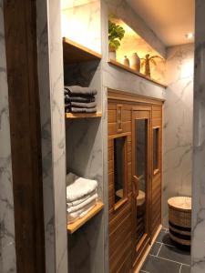 a bathroom with wooden shelves and towels at casa Heemskerk in Noordwijk