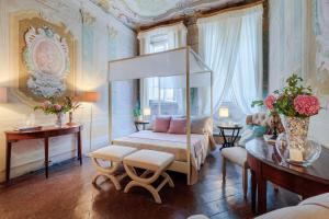 1 dormitorio con cama con dosel y mesa en Casa Penelope, en Lucca