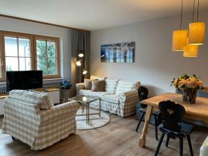 a living room with two couches and a table at Amelie Ferienwohnung in Garmisch-Partenkirchen