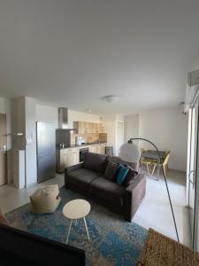 sala de estar con sofá y cocina en Appartement CUMARU vue mer, en Saint-Florent