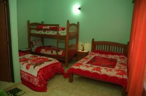 プエルトイグアスにあるHostel Peter Panのベッドルーム1室(ベッド2台、二段ベッド1組付)