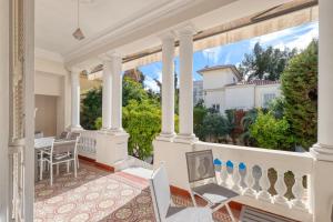 einen offenen Balkon mit einem Tisch und Stühlen darauf in der Unterkunft Stylish Art Deco villa near the sea 4 Bdrs Pool and garage in Nizza