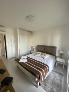 a bedroom with a large bed with two tables and a rug at Appartement CUMARU vue mer in Saint-Florent