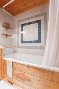 a bathroom with a tub and a shower curtain at L'Auberge du Choucas in Le Monêtier-les-Bains