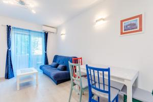 - un salon avec un canapé bleu, une table et des chaises dans l'établissement Apartment Karlo, à Kaštela