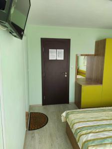 a bedroom with a bed and a mirror and a door at Guest House Perla in Obzor