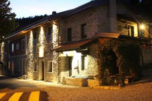 - un bâtiment en pierre avec des lumières sur le côté dans l'établissement Agriturismo La Nevera, à Lanzo dʼIntelvi