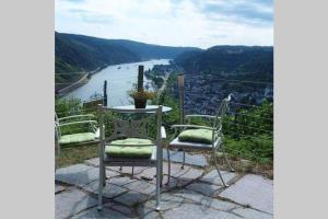 uma mesa e duas cadeiras com vista para um rio em Ferienwohnung Rheinblick Bacharach am Rhein em Bacharach