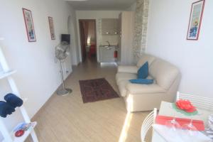 a living room with a white couch and a fan at Vernazza Vacation 2 in Vernazza