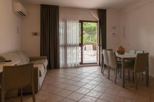 a living room with a couch and a table with chairs at Residence Crystal Palace in Milano Marittima
