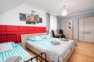 1 dormitorio con 2 camas y pared roja en Pokoje Jelonek en Władysławowo