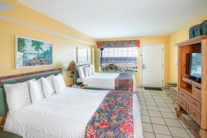 a hotel room with two beds and a television at Sea Shells Beach Club in Daytona Beach +16 photos