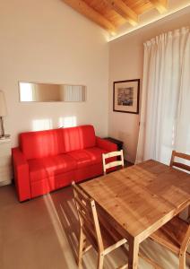 uma sala de estar com um sofá vermelho e uma mesa de madeira em Affittacamere L'Orto dei nonni em Levanto