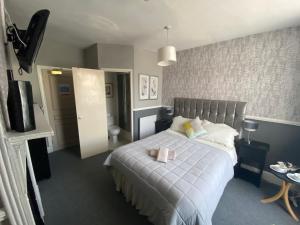 a bedroom with a large bed with a white blanket at Queens Hotel in St Bees
