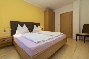 a bedroom with a large bed with white pillows at Stompferhof Familienapartment in Caldaro
