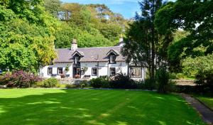 a white house with a large green lawn at The Lagg in Lagg