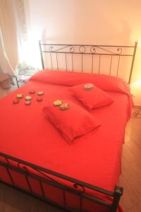 a red bed with red pillows and cookies on it at Vernazza Vacation 2 in Vernazza