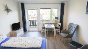 1 dormitorio con cama, escritorio y ventana en Nebelhorn-Appartments 124 - 206 - 210 - 213 - 216 - 217, en Oberstdorf