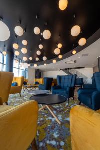 - une salle d'attente avec des chaises, une table et des lumières dans l'établissement Centrum Hotel Viljandi, à Viljandi