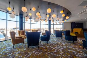 a waiting room with chairs and tables and windows at Centrum Hotel Viljandi in Viljandi