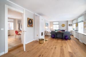 uma sala de estar com pisos em madeira e um quarto com uma mesa em Aggas Hues em Oldsum