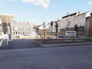 una calle vacía con una señal de respuesta de estacionamiento en una valla en La Cour en Charleville-Mézières