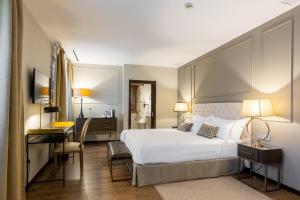 彼蒂高伊恩的住宿－伊利亞特約熱吉亞酒店，卧室配有一张白色大床和一张书桌