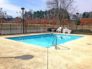 una piscina con 2 sillas y una mesa en Motel 6-Rocky Mount, NC en Rocky Mount