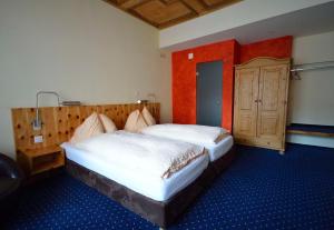 a bedroom with two beds and a wooden door at Ambiente Hotel Freieck in Chur