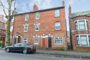 a black car parked in front of a brick building at Perfect for Contractors! Spacious 5bed house with Parking - Radford in Nottingham