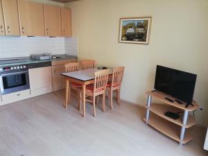 a kitchen with a table and chairs and a television at Urlaub auf dem Winzerhof Lamp in Weiler