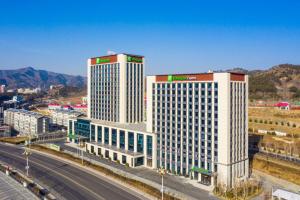 two tall buildings in a city next to a highway at Holiday Inn Chengde Park View, an IHG Hotel in Chengde