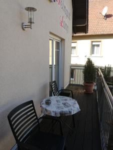 a patio with two chairs and a table on a balcony at Urlaub auf dem Winzerhof Lamp in Weiler