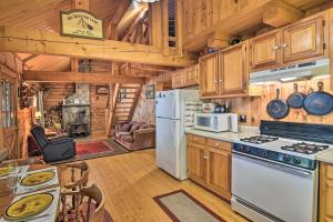 a kitchen with wooden cabinets and a white refrigerator at Lakeside Livin Cozy Cabin Steps to Sebec Lake! 