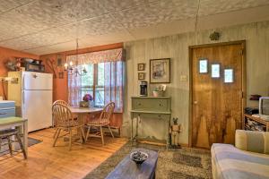 cocina y sala de estar con mesa y nevera en Wee Humble Cottage with Area Hunting and Canoeing!, en Bedford