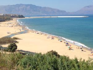 een strand met een stel mensen op het zand bij La stanza vicino al mare , una camera da letto e bagno con balcone vista mare in Balestrate