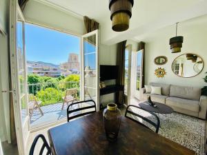 sala de estar con mesa, sillas y ventana grande en Granada Luxury Apartments by Apolo Homes, en Granada