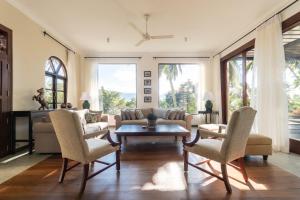 een woonkamer met een bank, stoelen en een tafel bij Villa Merak, Digana in Digana